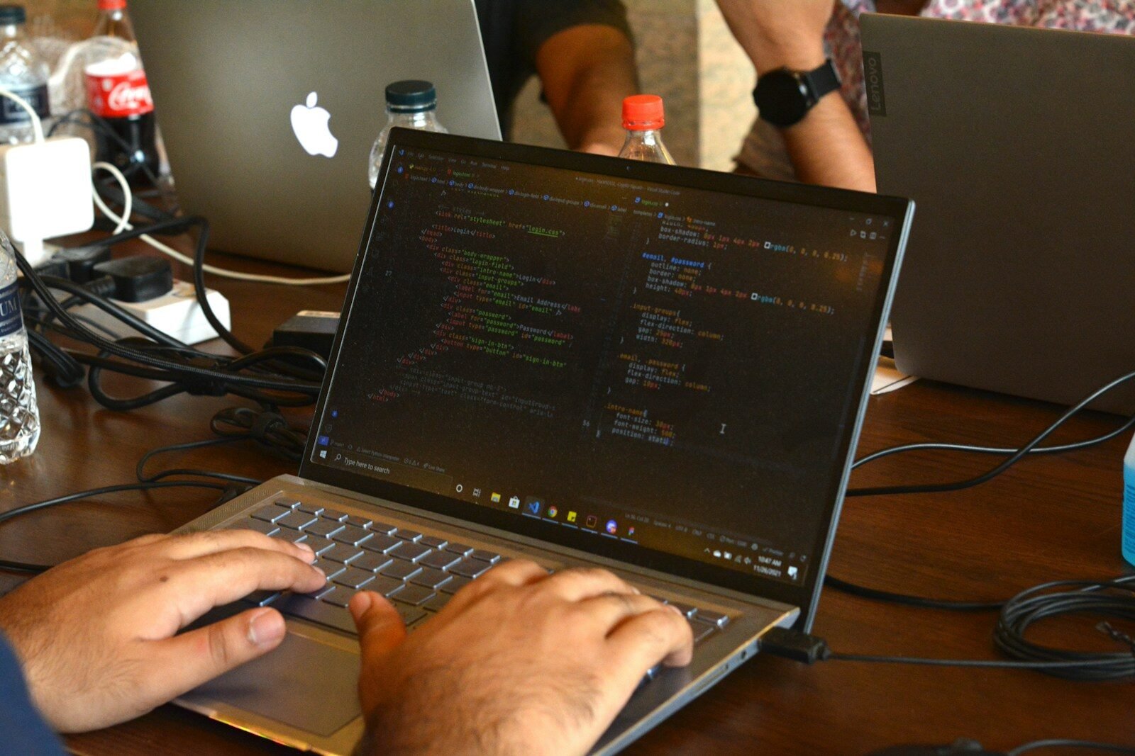 Photo by Fahim Muntashir a man using a laptop computer on a wooden table